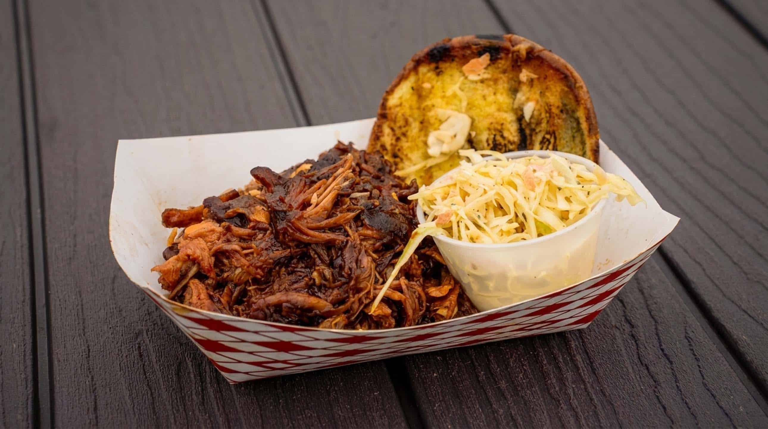 A catering basket of barbecue with garlic bread and slaw from Ahh la Cart